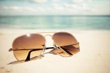 Close up of aviator sunglasses in the sand on a sunny day