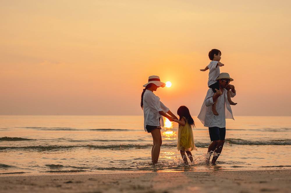 Family walking on the beach at sunset