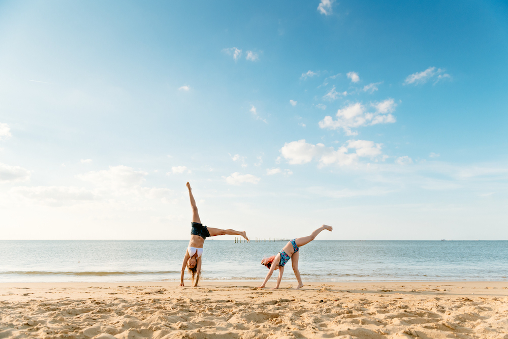 girls doing cartwheels on beach