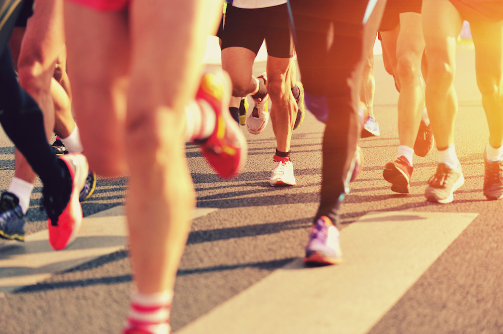 marathon runners on street, view of legs